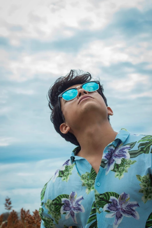 a man wearing blue sunglasses looking up