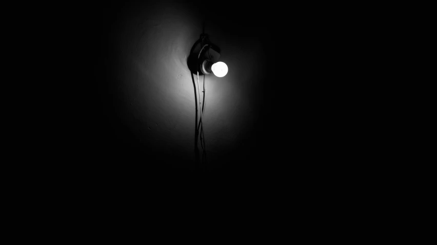 a street light shining in the dark on a wall