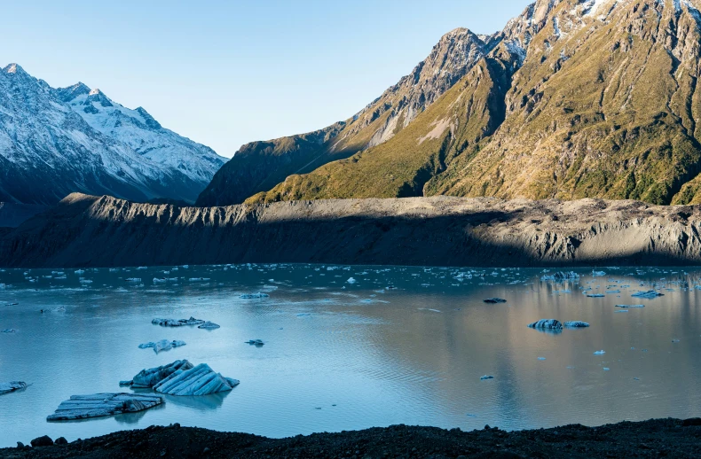 a lake is surrounded by large mountains that cover them