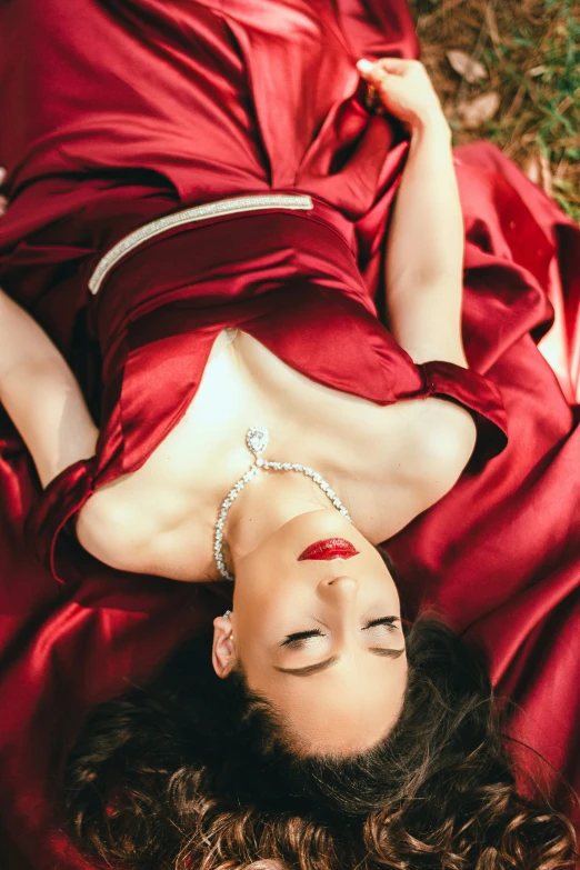 woman in red dress laying on the grass