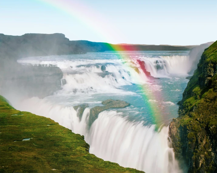 there is a rainbow in the sky over a waterfall