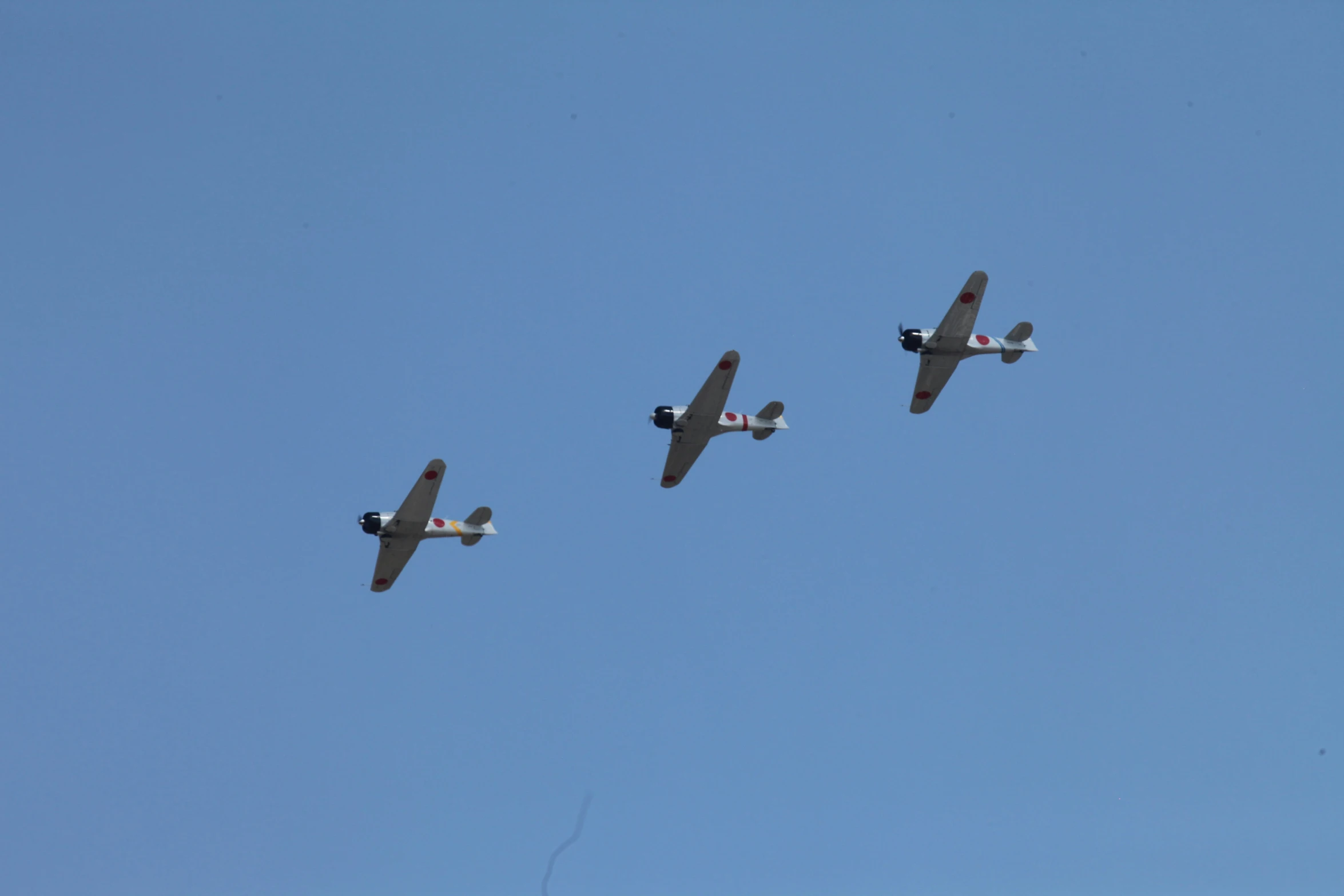 three planes flying close together in a blue sky