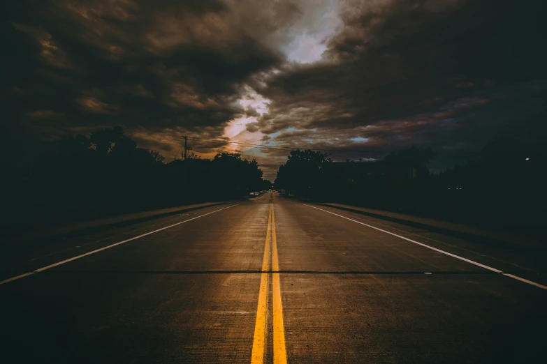 a very long road near some houses and trees