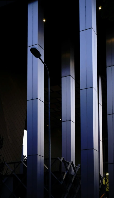 the back view of a tall pole and some street lamps