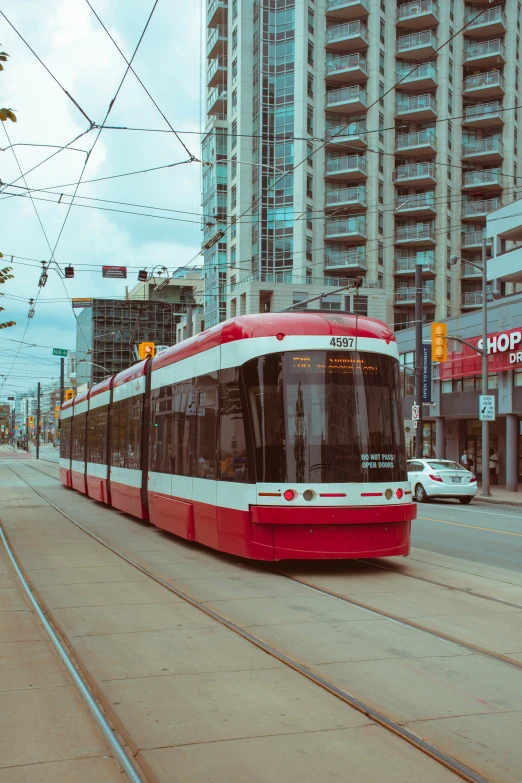 a red and white tram car on a street