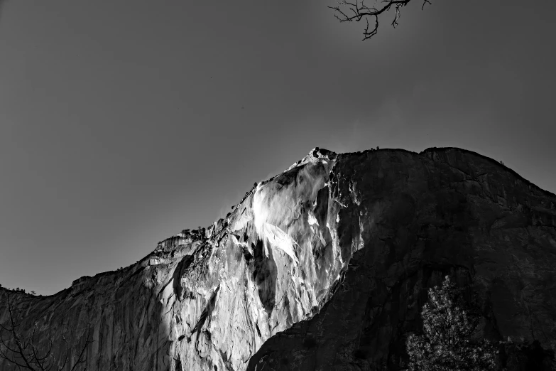 a mountain covered in snow under a cloudy sky