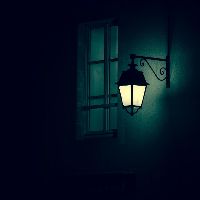 a lamp on the wall in a dark room