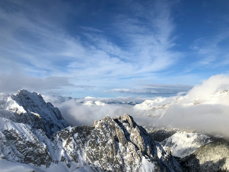 snow covered mountain peaks under a partly cloudy sky