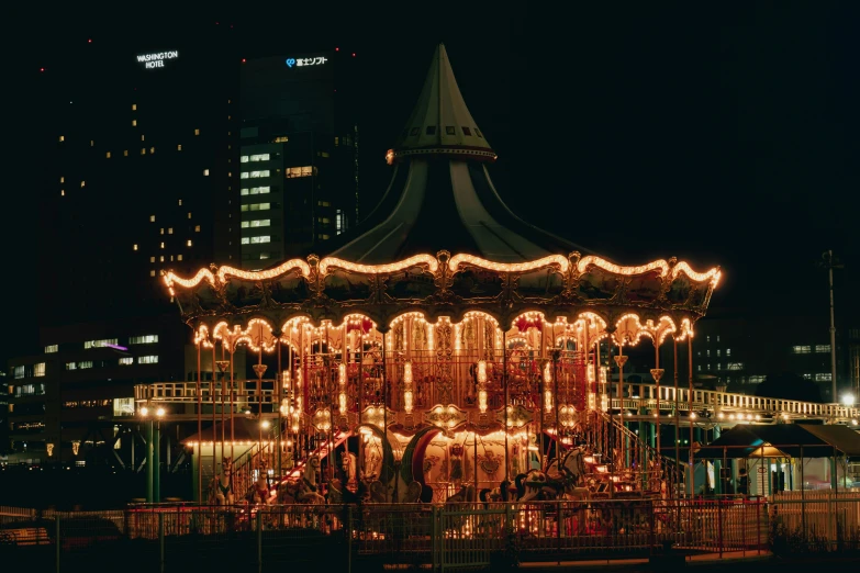 a merry go round in the middle of the city at night