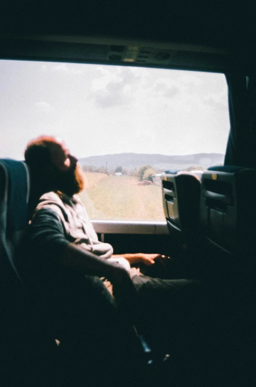 a man with a beard is looking out the window of his truck