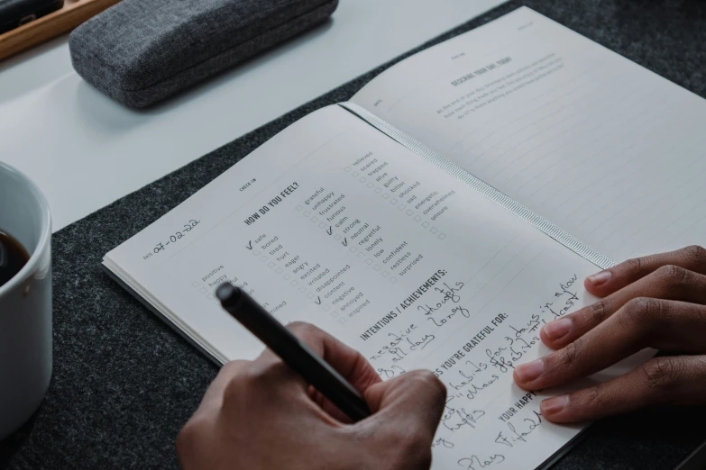 someone writing down a workbook on a table