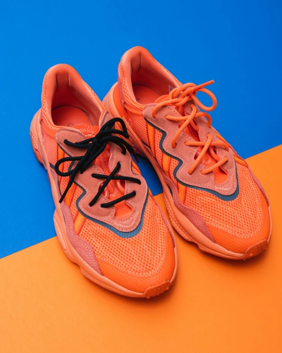 a pair of orange tennis shoes on an orange and blue surface