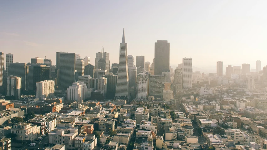 a city skyline with tall buildings and a blue sky