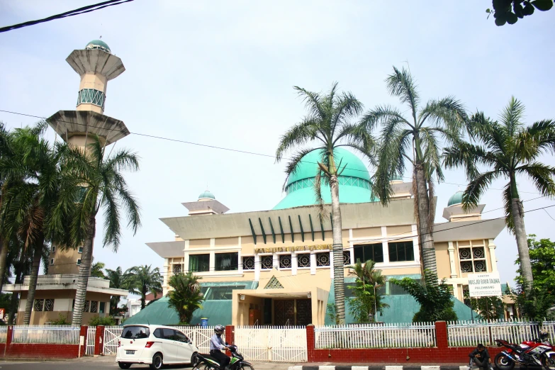 a large building with a green dome sitting on the corner next to a traffic circle
