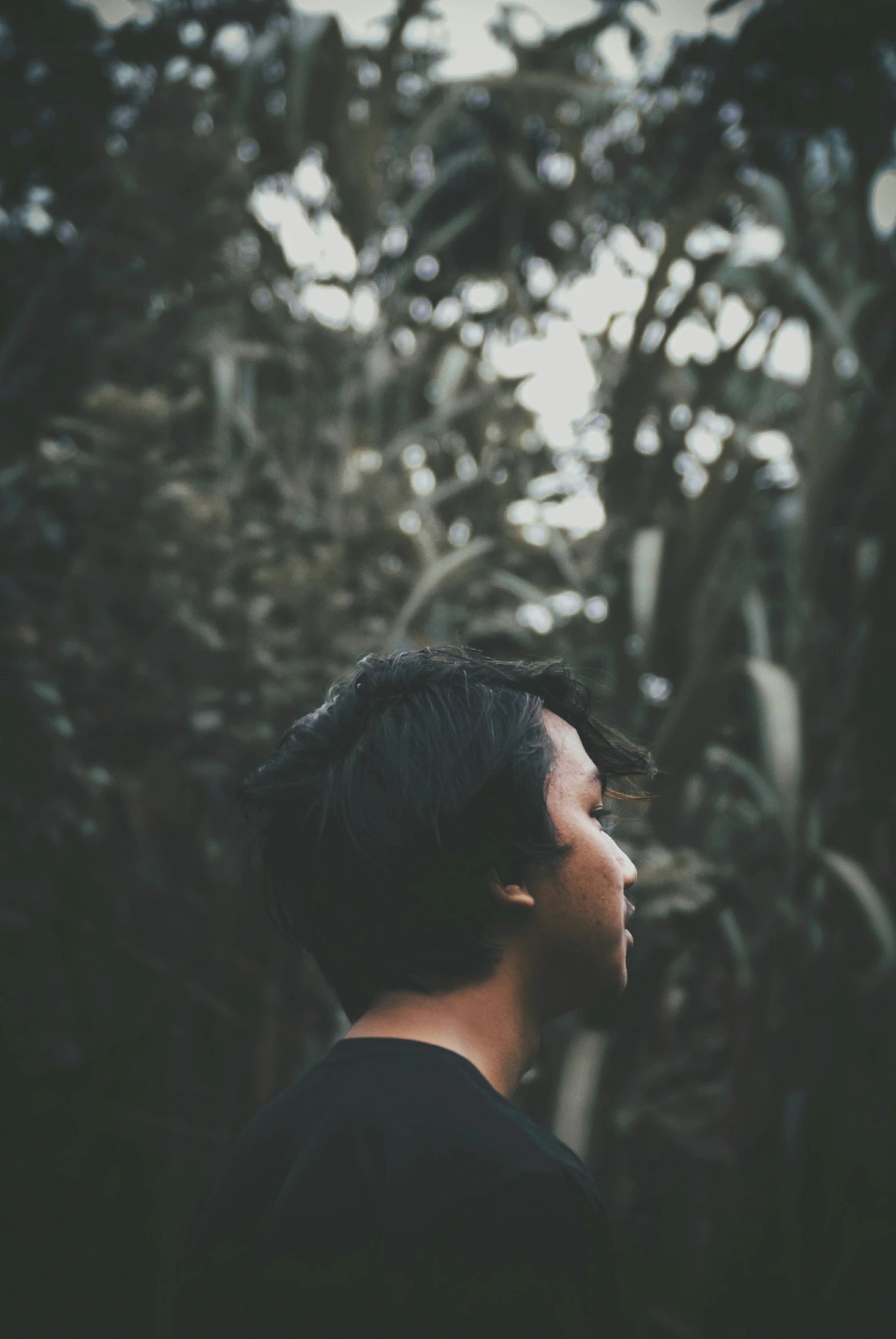 a man in a black shirt stares up into the distance