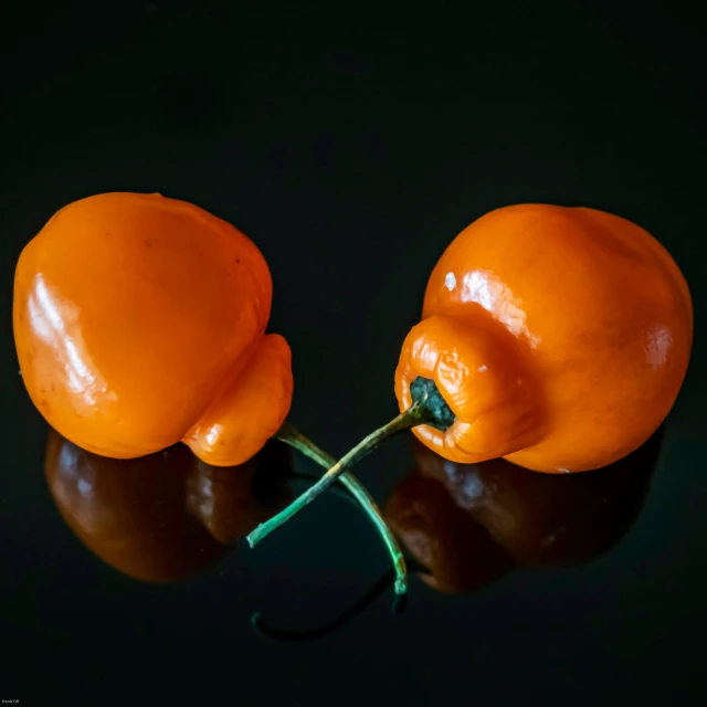 three orange peppers one of which is split in half