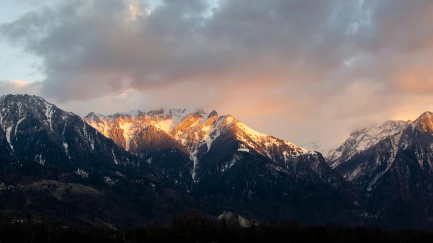 the mountains and sky are covered with bright clouds