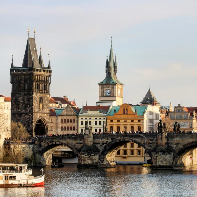 old town buildings sit along the river while boats are on the water