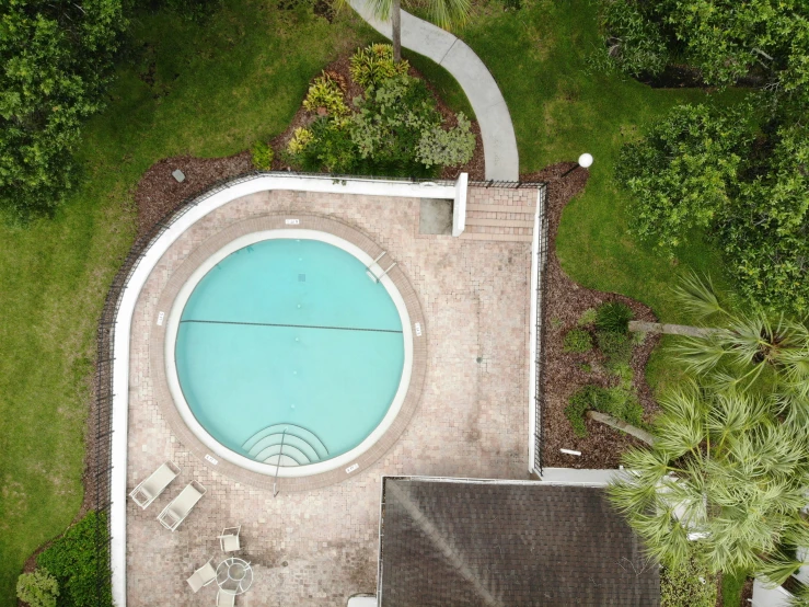 an overhead s of a pool with a white umbrella