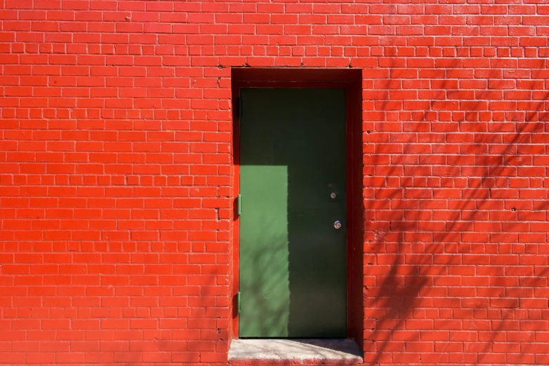 there is a green door and a red brick wall