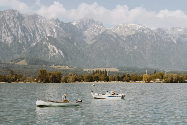 several boats in the water with mountains in the distance