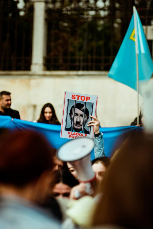 a man holding a sign in the middle of a crowd