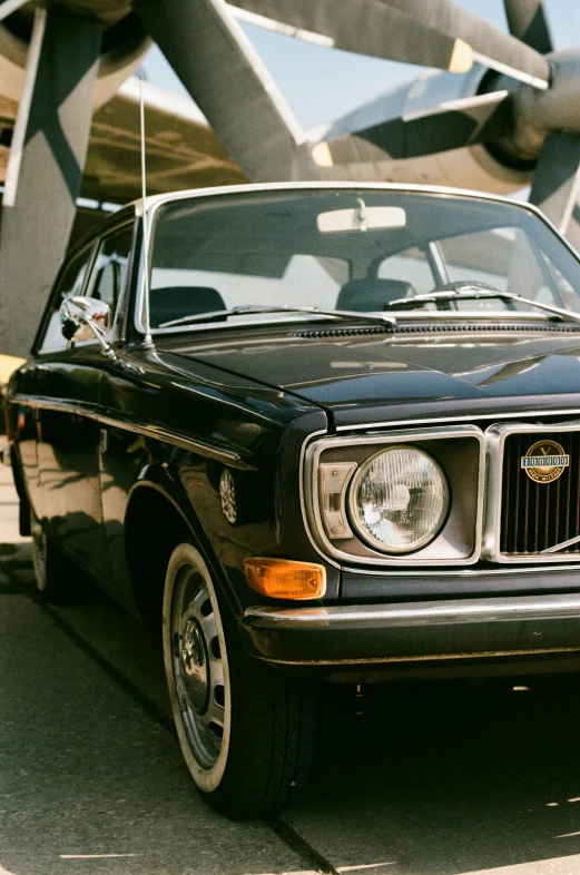 an old fashioned black car parked next to a building