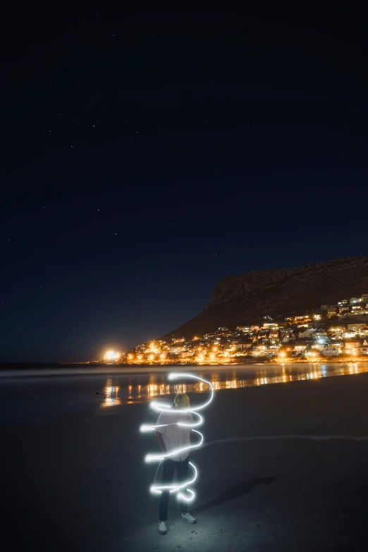 a person on the beach holding a kite string at night