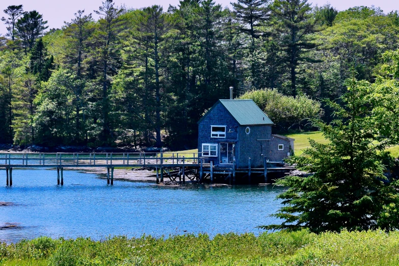 an old house with a wooden walkway across a body of water