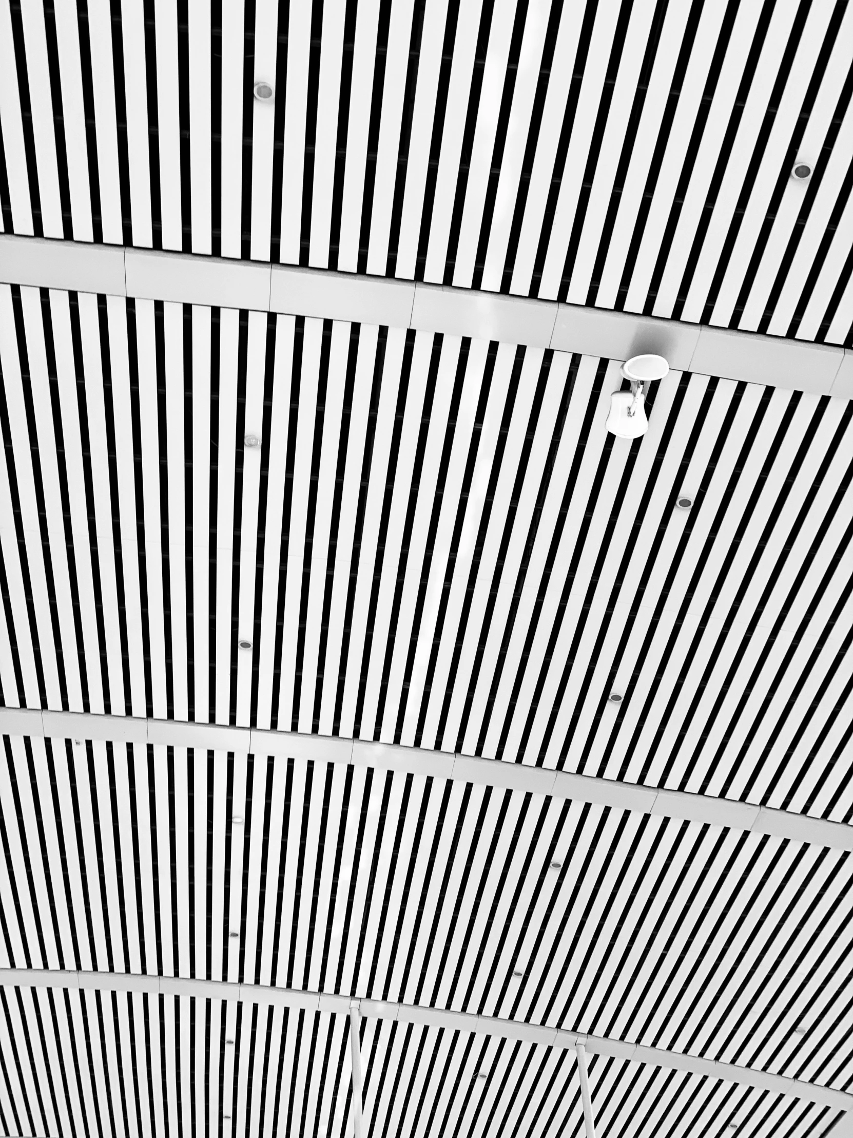 a white ceiling with a white ceiling lamp and a black stripe ceiling