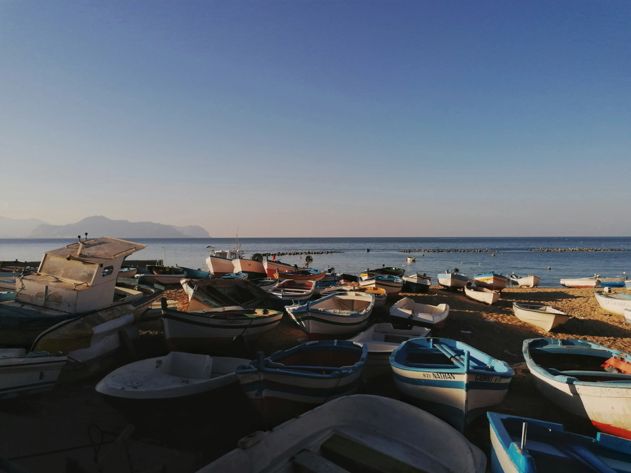 many boats in the water next to a pier