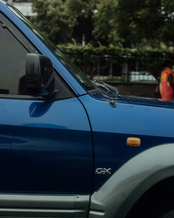 a blue car that is driving down the street