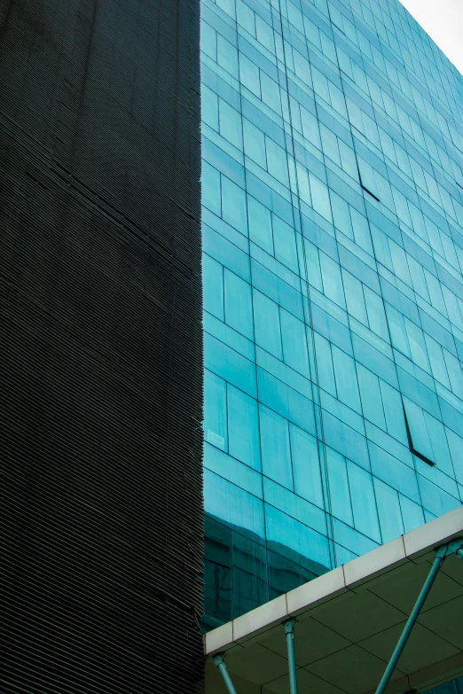 a tall building next to a very large glass building