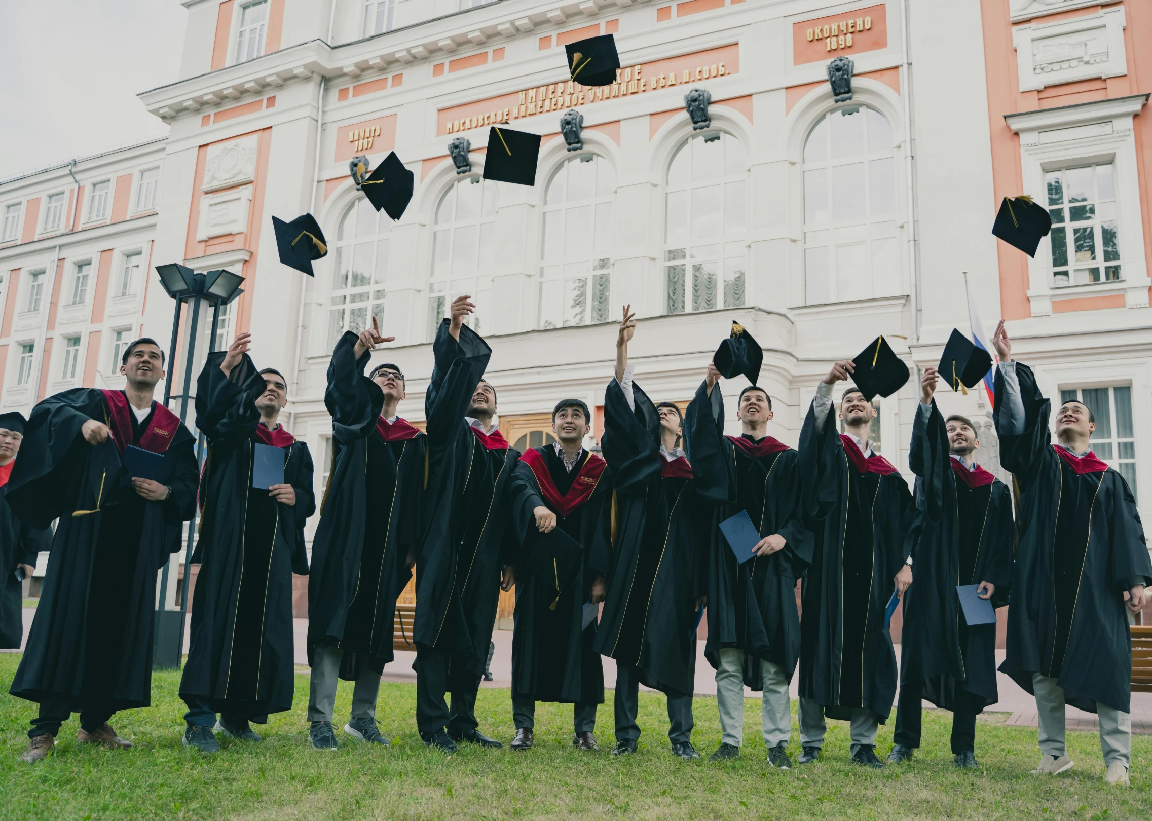 graduates in graduation gowns throwing their caps in the air