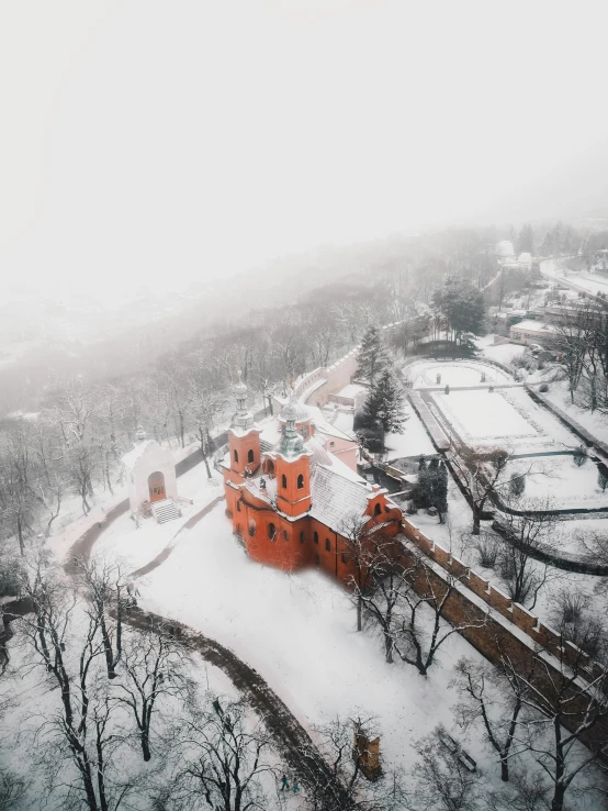 an aerial view of a large estate surrounded by a snow covered forest