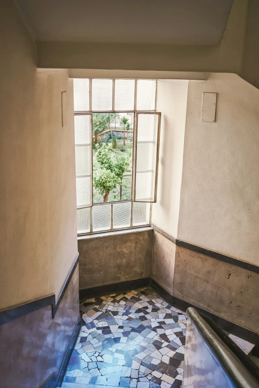 an empty room with an open window and a tiled floor