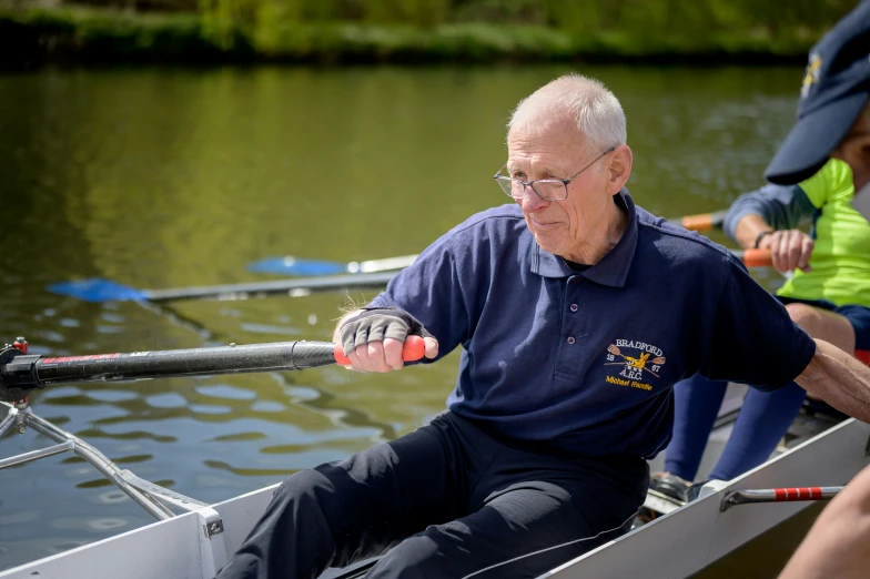 a man in a blue shirt rowing on water