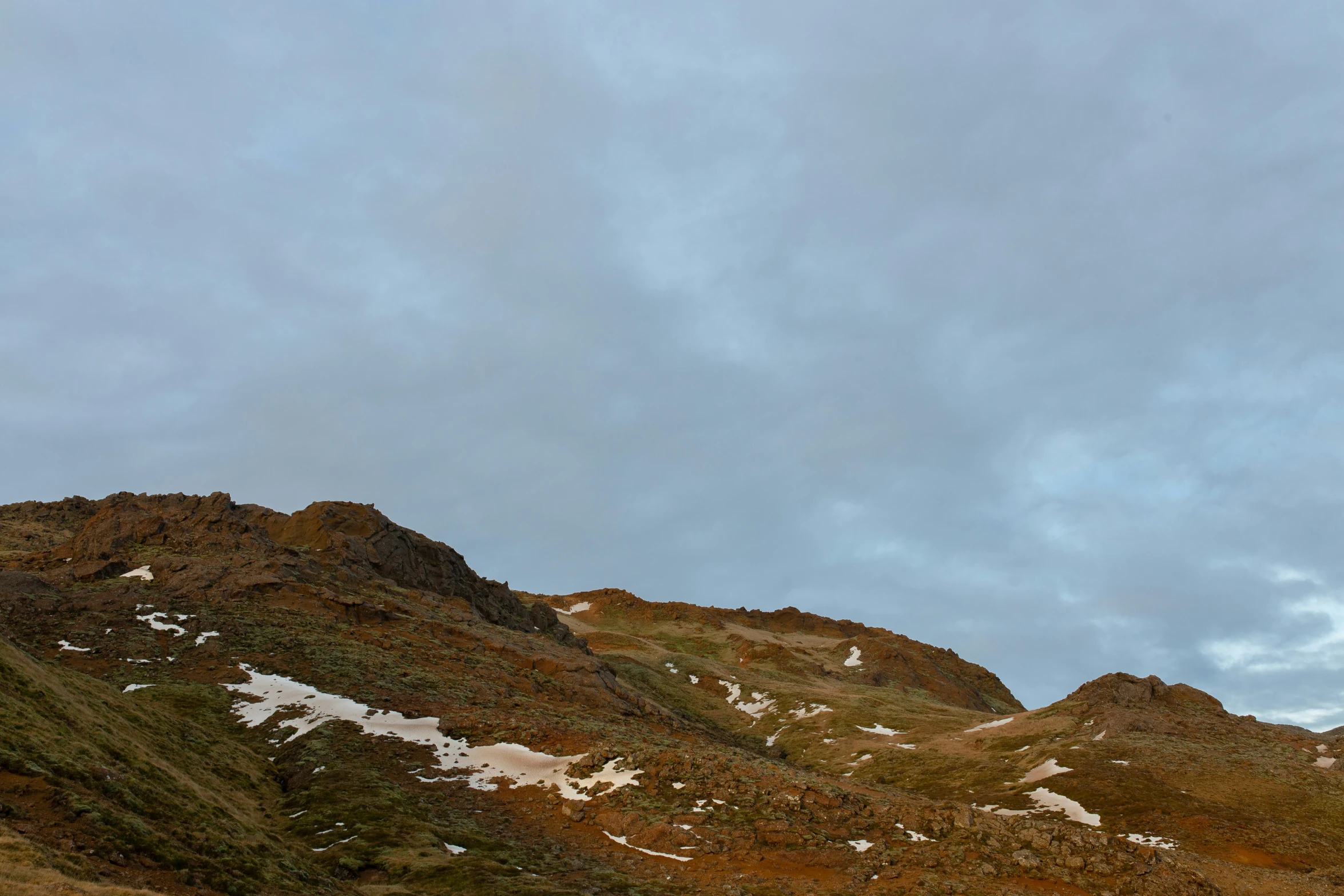 two people with backpacks walking up a mountain