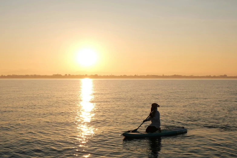 a woman riding a paddle boat in a body of water