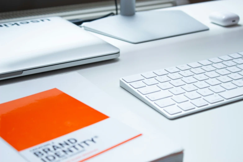 a keyboard, mouse and book on a desk