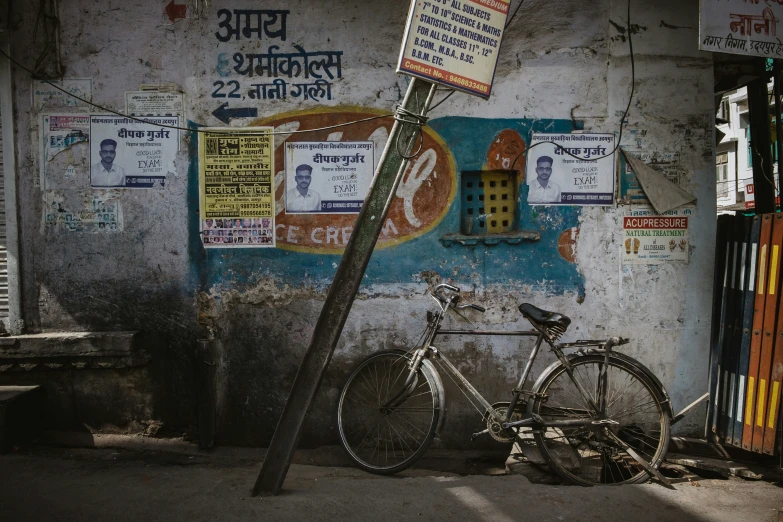 a bicycle parked next to a street sign near a building