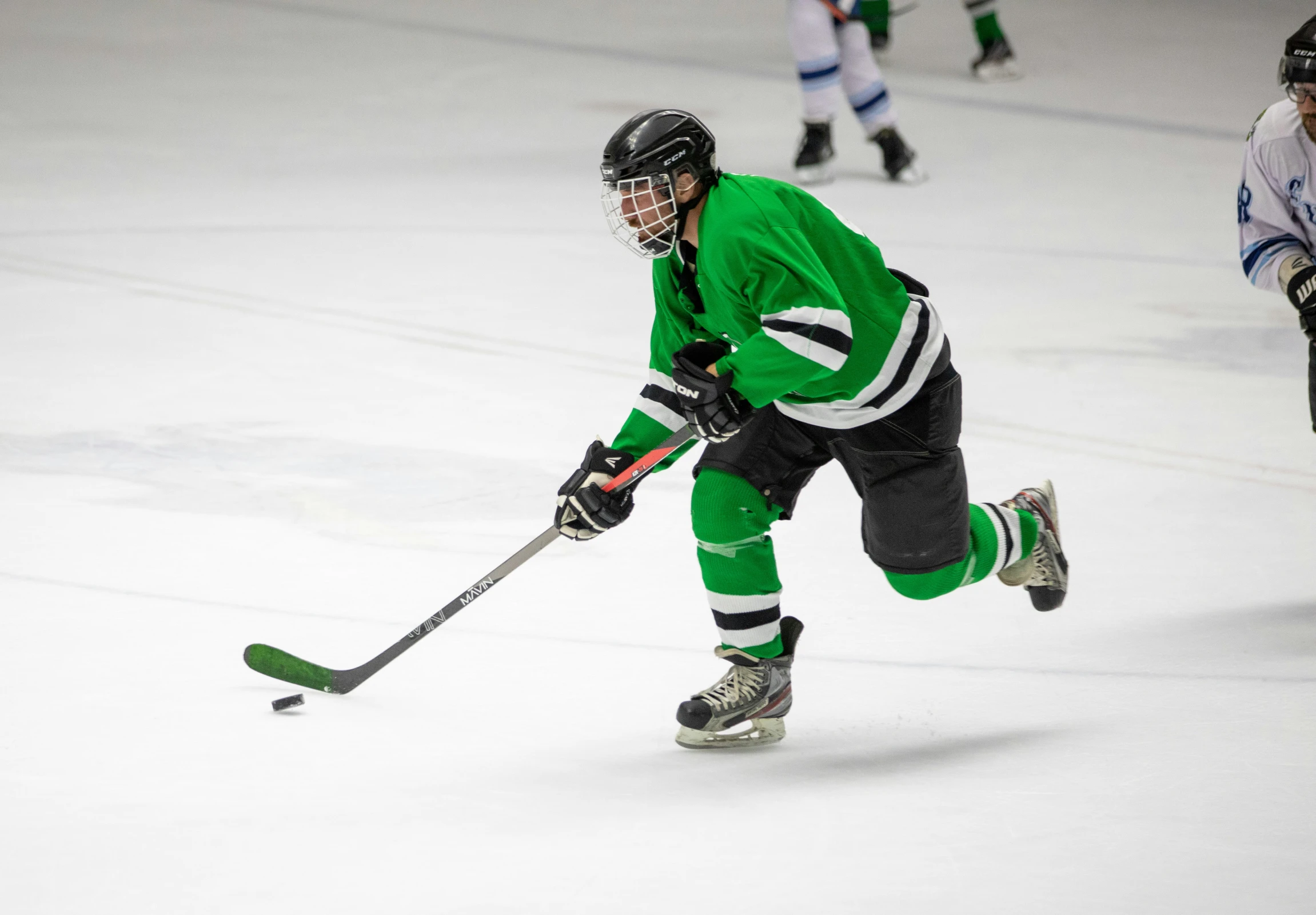 several young people play a game of ice hockey