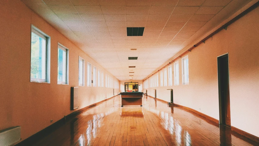 a long empty hallway with multiple windows and lights