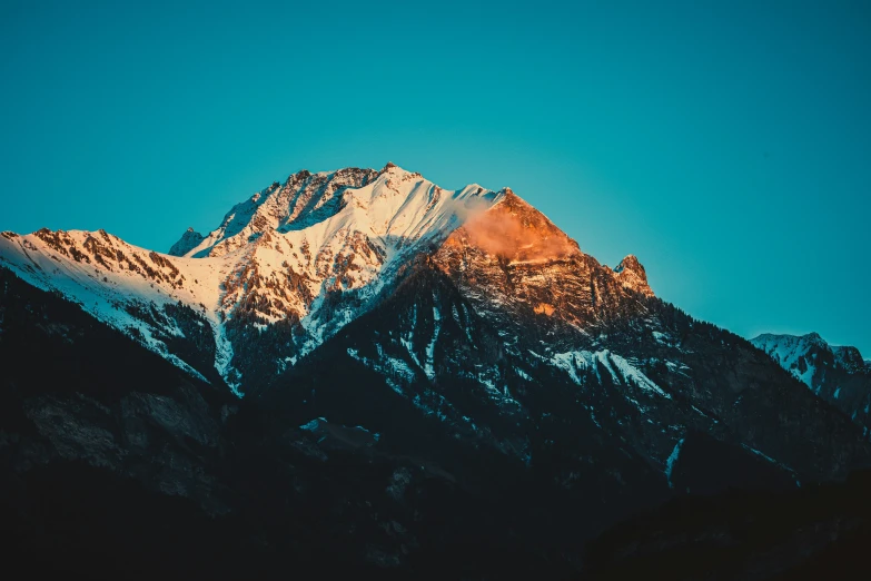 a snow - covered mountain, with a clear blue sky