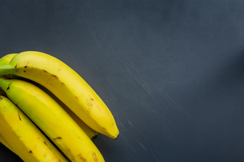 a group of bananas are sitting on a black surface