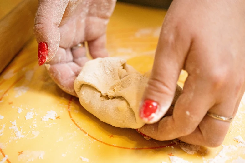 the person is putting the dough on top of the dough