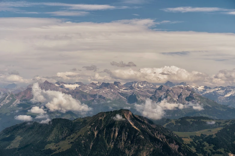 a small group of mountains and clouds above them