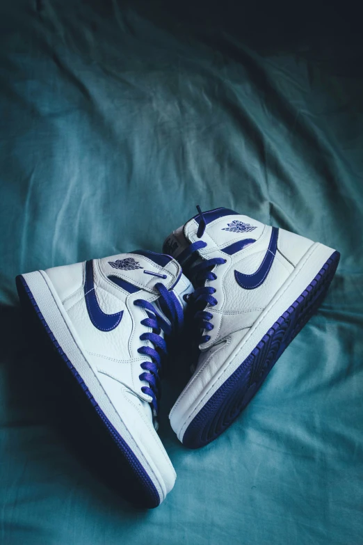 a pair of white shoes on top of a bed