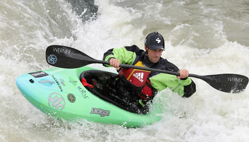 a man that is on the back of a kayak in the water