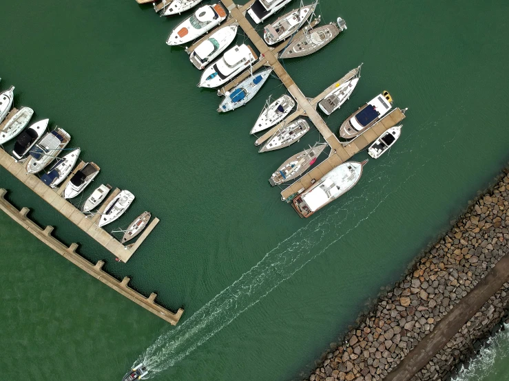 boats docked in harbor with jetty in the middle